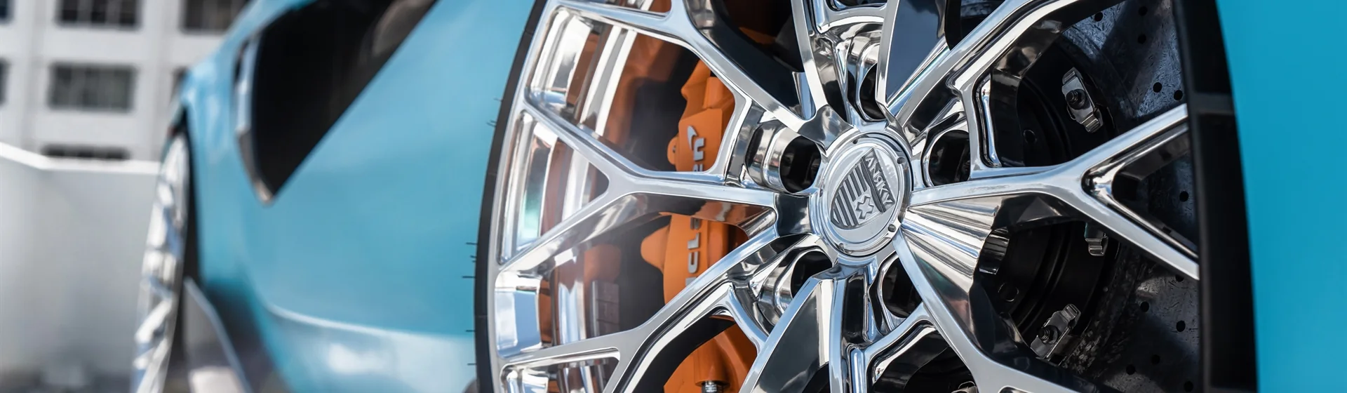 Close-up of a polished VIVE wheel on a blue vehicle